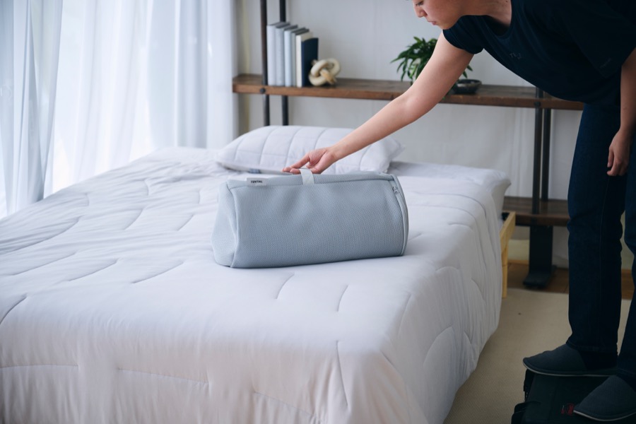 掛け布団を収納バッグに入れる様子